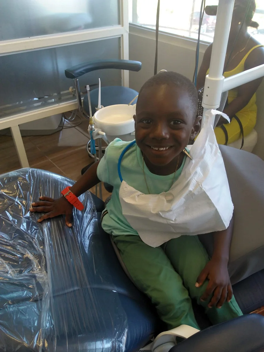 A young patient sitting up and smiling in an Elite Smiles treatment room