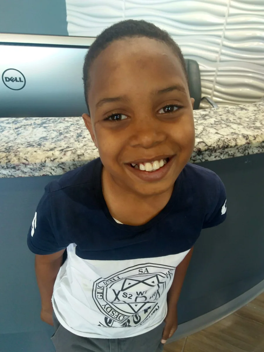 A young patient sharing a big smile at the front desk