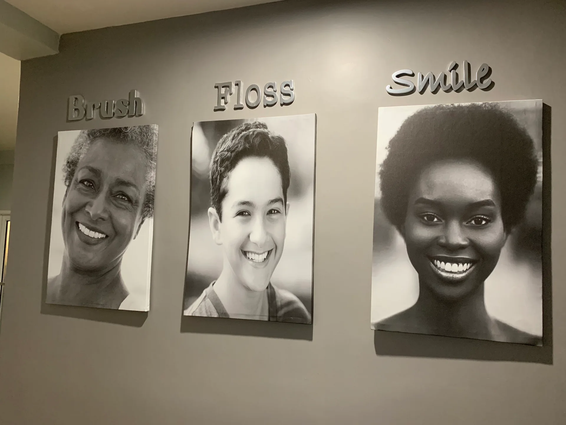 Three smiling portraits under Brush, Floss and Smile lettering at Elite Smiles